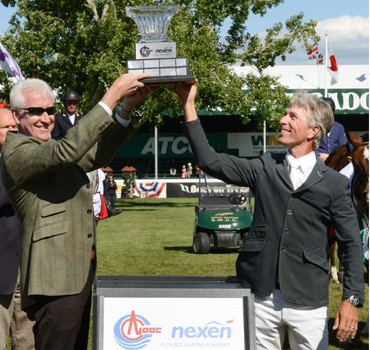 Richard Spooner hoists the champions trophy with Patrick McViegh, Sr. Vice President, Exploration and International Development at CNOOC Nexen. Photo (c) Spruce Meadows Media Services.