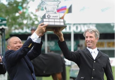 Richard Spooner lifts the Nexen Cup with Mr. Fang Zhi, CEO, Nexen ULC. © Spruce Meadows Media Services.