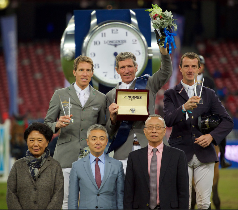 The prize-giving ceremony of the Longines Grand Prix with Henrik von Eckermann, Ludger Beerbaum and Gregory Wathelet on the podium and Jing Li, CEO of Dashing Equestrian, Dennis Li, vice-president of Longines China, and Li Nianxi, chief secretary of the Chinese Equestrian Association, in the front. Photo (c) Longines Equestrian Beijing Masters/Arnd Bronkhorst.  
