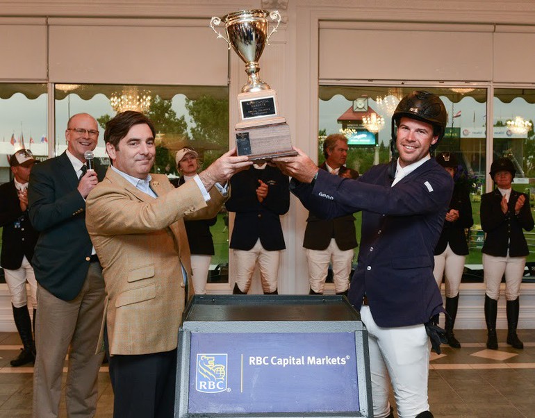 Winner Jack Hardin Towell Jr. hoists the champions trophy with D avid Dal Bello - Managing Director at RBC Capital Markets. Photo (c) Spruce Meadows Media Services. 