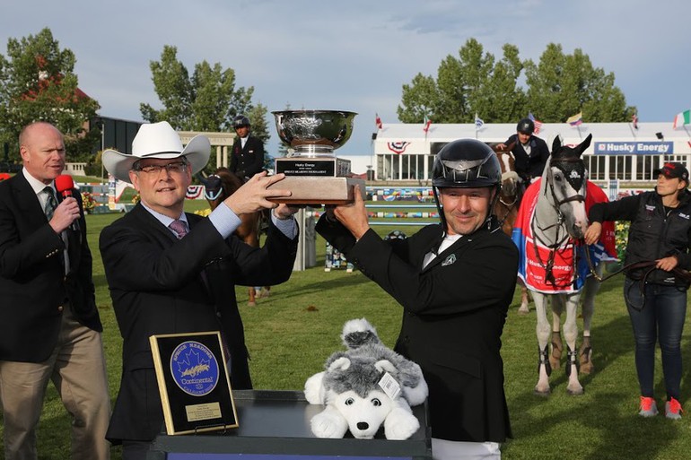 Eric Lamaze hoists the champions’ trophy with Rob Peabody, Chief Operating Officer at Husky Energy. Photo (c) Spruce Meadows Media Services. 