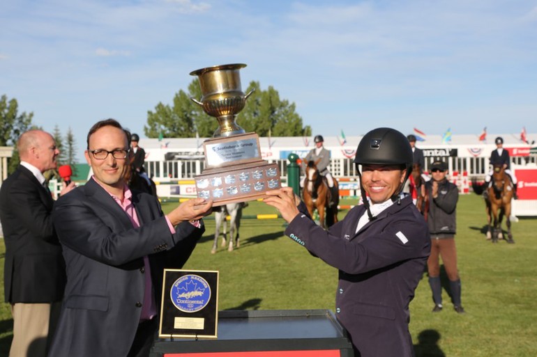 Kent Farrington hoists the Champions trophy with Tony Aulicino, Managing Director at Scotiabank