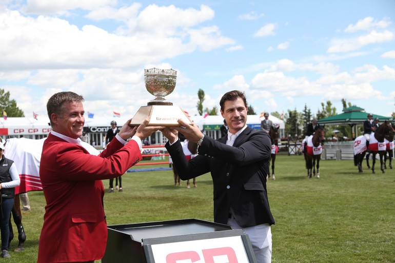 Peter Lutz hoists the champions trophy with Keith Creel, President and COO, CP Rail. Photo (c) Spruce Meadows Media Services.