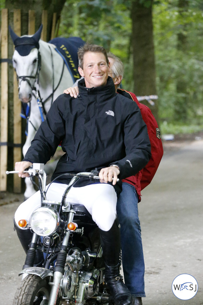 It is a long way between the stable and the arena, so everybody has something on wheels helping them getting there faster: Here Daniel Deusser with German team vet Jan-Hein Swagemakers. 