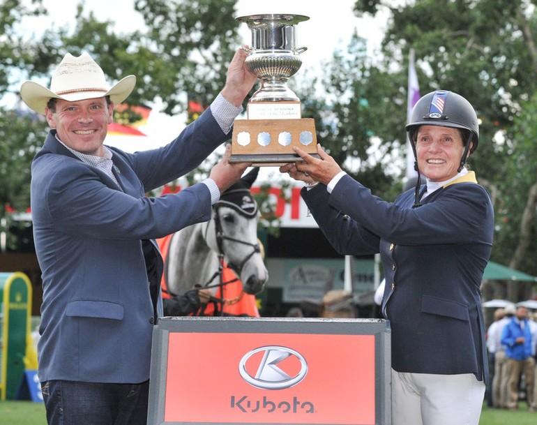 Leslie Howard USA hoists the champions trophy with Carl Heinlein, General Manager, sales & Marketing, Kubota Canada. Photo (c) Spruce Meadows Media Services.