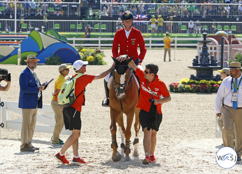 Daniel Deusser and First Class delivered the third clear round for Germany. Groom Sean Lynch and team vet Jan-Hein Swagemakers were the first to congratulate. 