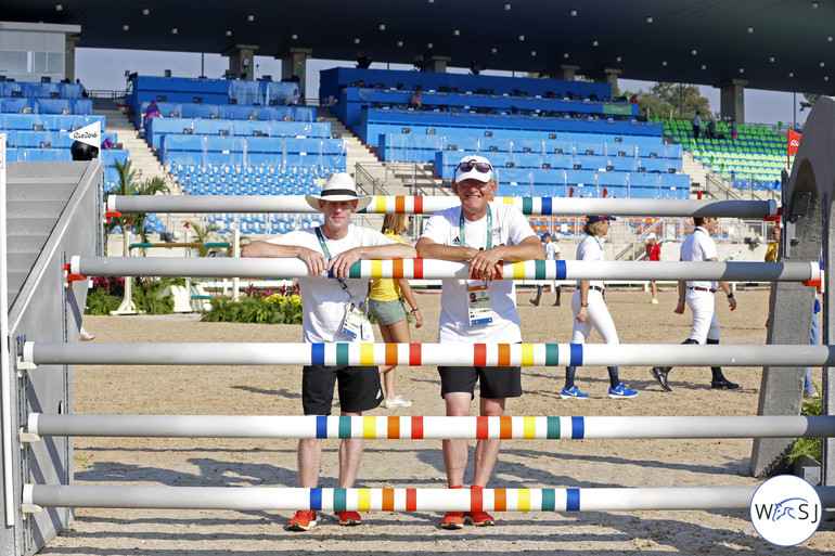 Marcus Ehning and Heiner Engemann posing in the middle of the triple bar. 