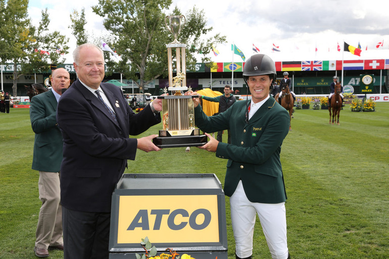 Pedro Veniss (BRA) hoists the championship trophy with Siegfried Kiefer President & Chief Operating Officer, Canadian Utilities. Photo (c) Spruce Meadows Media Services. 